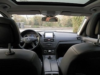 Het interieur van de Mercedes C220 CDI lesauto, met dashboard, stuur en versnellingspook