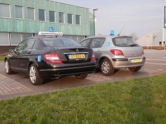 De Mercedes en de Peugeot lesauto van Autorijschool Actief achter elkaar geparkeerd